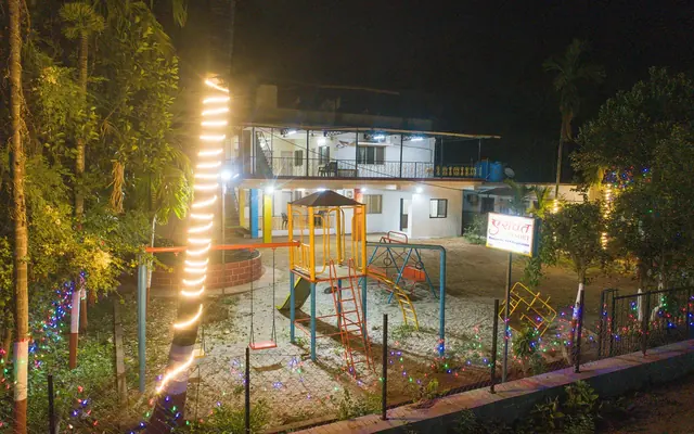 Airawat Resort lit up at night, with the garden and play area