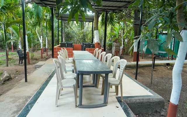 Long outdoor dining table under a shaded pergola at Airawat