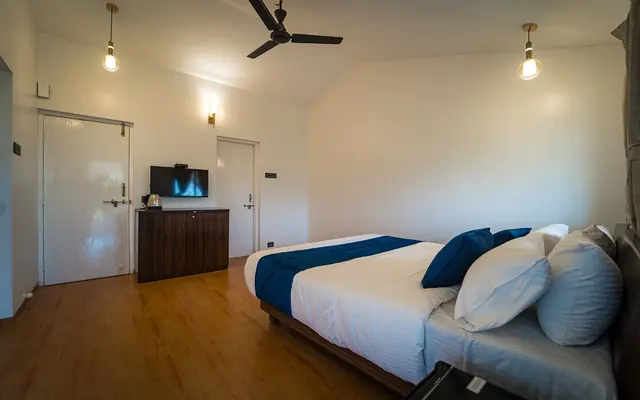 Bedroom at Redroof with blue cushions and a ceiling fan